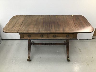 Lot 144 - Regency style mahogany sofa table, hinged crossbanded top with reeded edge and two frieze drawers on standard ends and splayed legs terminating in brass cappings and castors, 91cm wide x 61cm deep...