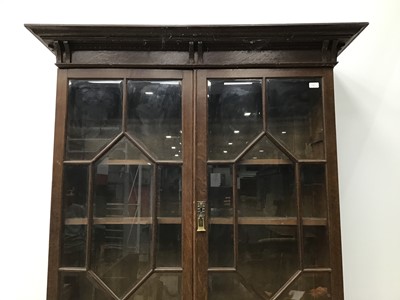 Lot 164 - Edwardian oak two height secretaire bookcase with moulded cornice, adjustable wooden shelves enclosed by two bevelled glazed doors, fitted secretaire drawer and cupboard below enclosed by two carve...
