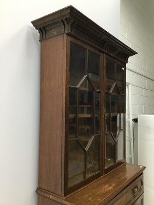 Lot 164 - Edwardian oak two height secretaire bookcase with moulded cornice, adjustable wooden shelves enclosed by two bevelled glazed doors, fitted secretaire drawer and cupboard below enclosed by two carve...