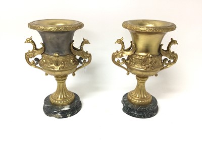 Lot 18 - Pair of gilt metal urns, on marble pedestals