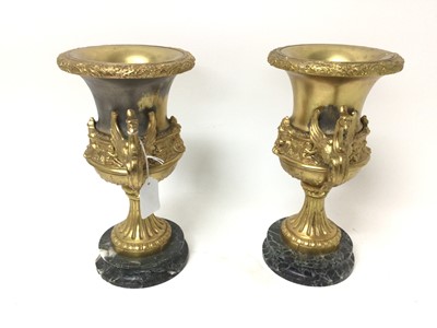Lot 18 - Pair of gilt metal urns, on marble pedestals