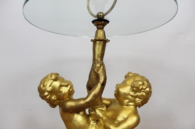 Lot 105 - Occasional table with circular glass top on gesso putti supports