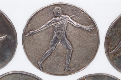 Lot 982 - Five silver Greek roundels, by Antigone Filippaki each circular embossed disc representing athletic disciplines, stamped marks and numbered .999, 10cm diameter, in marble frame mount