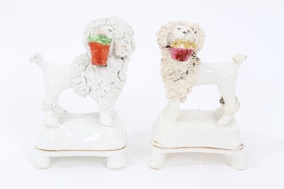 Lot 29 - Two Staffordshire porcelain poodles with baskets, c.1840, highlighted in enamels and gilt, 9.5cm height