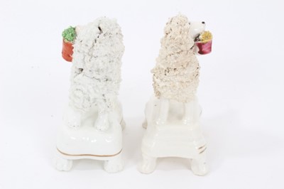 Lot 159 - Two Staffordshire porcelain poodles with baskets, c.1840, highlighted in enamels and gilt, 9.5cm height