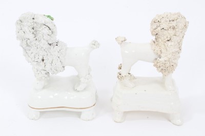 Lot 29 - Two Staffordshire porcelain poodles with baskets, c.1840, highlighted in enamels and gilt, 9.5cm height