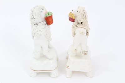 Lot 159 - Two Staffordshire porcelain poodles with baskets, c.1840, highlighted in enamels and gilt, 9.5cm height