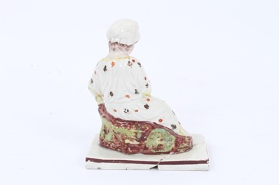 Lot 71 - Four Staffordshire pearlware figures, c.1800, including two reclining figures, possibly representing seasons, a kneeling woman, and a woman carrying a chicken, all with red-lined square bases, betw...