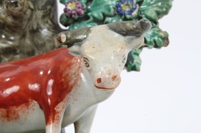 Lot 85 - Staffordshire pearlware spill vase by Walton, c.1820, in the form of a cow and calf on a grassy mound, with bocage and tree behind them, inscribed 'Walton' verso, 18.5cm height