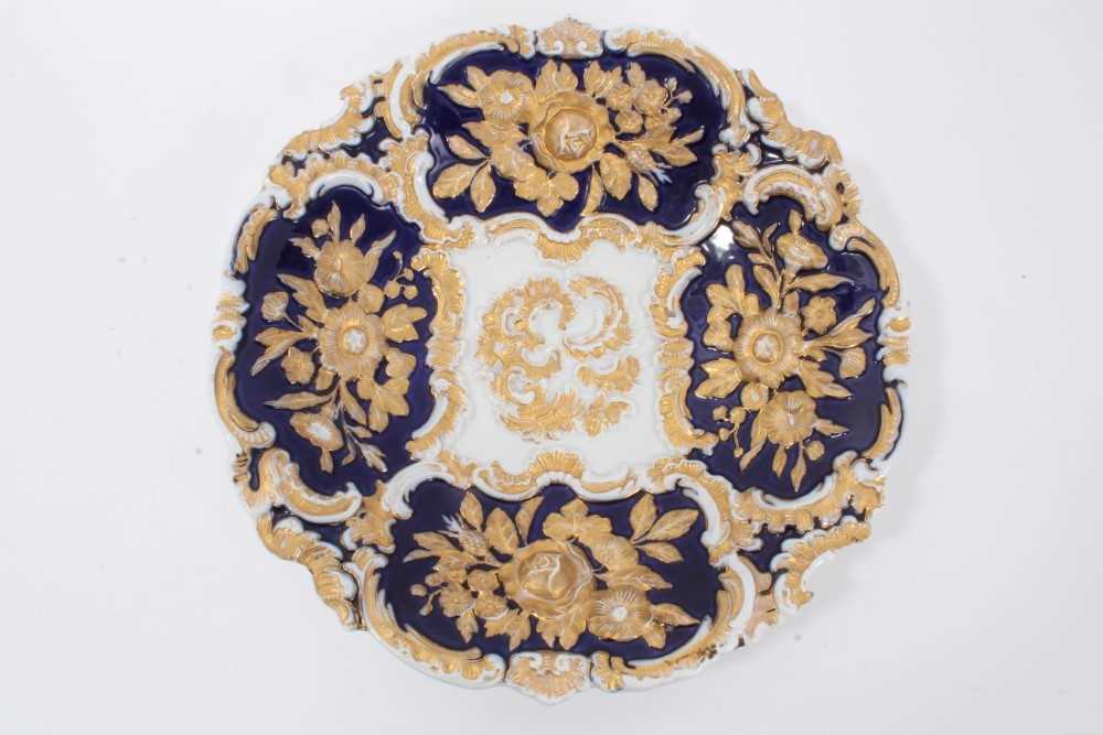 Lot 78 - Meissen gilt-highlighted cobalt blue dish, decorated with flowers in relief, crossed swords mark to base, 30cm diameter