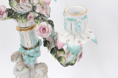 Lot 79 - Pair of Dresden figural porcelain candelabra, with three branch section fitting on to a central column, with floral encrusted decoration, marks to bases, total height 47cm