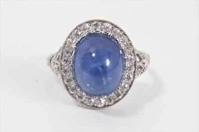 Lot 319 - Edwardian style sapphire and diamond cluster ring with an oval cabochon blue sapphire weighing approximately 8.49cts surrounded by a border of old cut diamonds in millegrain setting with pierced ga...