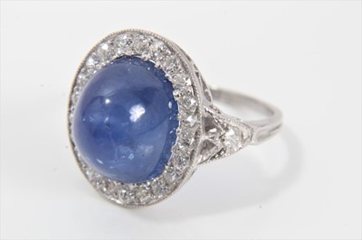 Lot 319 - Edwardian style sapphire and diamond cluster ring with an oval cabochon blue sapphire weighing approximately 8.49cts surrounded by a border of old cut diamonds in millegrain setting with pierced ga...
