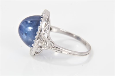 Lot 319 - Edwardian style sapphire and diamond cluster ring with an oval cabochon blue sapphire weighing approximately 8.49cts surrounded by a border of old cut diamonds in millegrain setting with pierced ga...