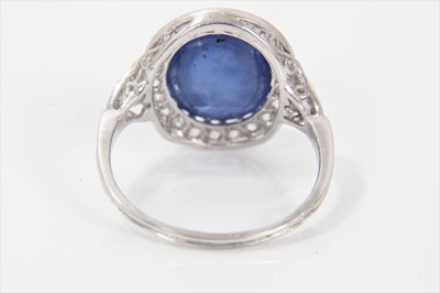 Lot 319 - Edwardian style sapphire and diamond cluster ring with an oval cabochon blue sapphire weighing approximately 8.49cts surrounded by a border of old cut diamonds in millegrain setting with pierced ga...