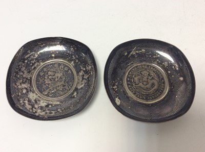 Lot 181 - Pair of Chinese silver pin dishes set with coins, marked 800 to unsides, all at approximately 6oz, each 8.3cm in diameter (2)