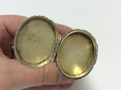 Lot 133 - Late 19th century Continental silver combination vesta case and pill box of oval cylindrical form with chased floral and scroll decoration and hinged covers, 7.1cm in overall length