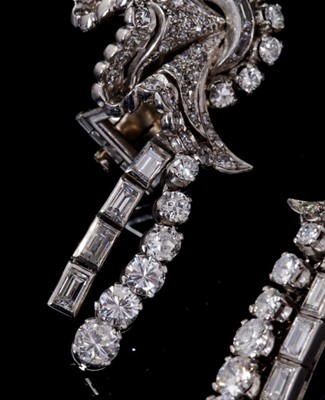 Lot 241 - Pair of Art Deco diamond earrings, each with a stylized fan with pavé set diamonds, single-cut, brilliant cut and baguette cut diamonds, suspending an articulated pendant drop of graduated baguette...