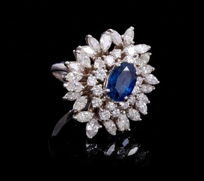 Lot 245 - Sapphire and diamond cluster cocktail ring with an oval mixed cut blue sapphire estimated to weigh approximately 1.75cts surrounded by 18 brilliant cut and 24 marquise cut diamonds in tiered claw s...