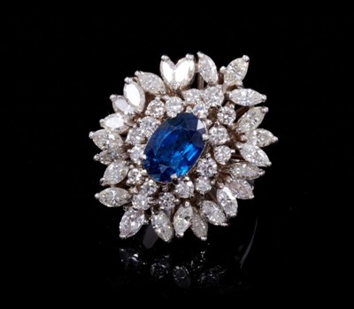 Lot 245 - Sapphire and diamond cluster cocktail ring with an oval mixed cut blue sapphire estimated to weigh approximately 1.75cts surrounded by 18 brilliant cut and 24 marquise cut diamonds in tiered claw s...