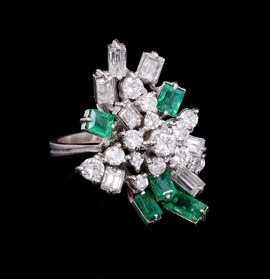 Lot 252 - Emerald and diamond cluster cocktail ring with an asymmetrical cluster of brilliant cut an baguette cut diamonds, and rectangular step cut emeralds, all in tiered claw setting on 18ct white gold sh...