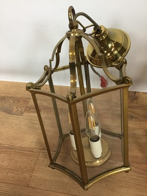 Lot 822 - Set of three Georgian style brass hanging hall lanterns, each of hexagonal form with bowed glass housing three lights, total height 41cm