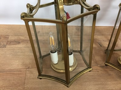 Lot 822 - Set of three Georgian style brass hanging hall lanterns, each of hexagonal form with bowed glass housing three lights, total height 41cm