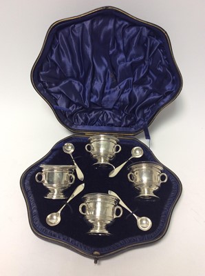 Lot 205 - Set of four Edwardian silver salts in the form of tyg's with removable clear glass liners and matching spoons, (London 1902), maker Z Barraclough & Sons, in velvet lined fitted case, all at 9oz