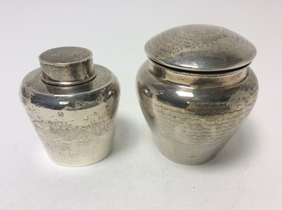 Lot 206 - George V silver tea caddy of oval form with push fit cover (Birmingham 1922), together with another George V silver tea caddy / tobacco pot with engine turned decoration (Birmingham 1919),  all at...