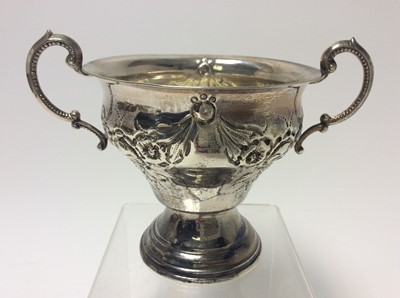Lot 208 - George V silver of two handled bowl of tapered form with embossed floral decoration, raised on circular pedestal foot, (London 1918), maker Rosenzweig, Taitelbaum & Co, approximately 7oz, 11.3cm in...