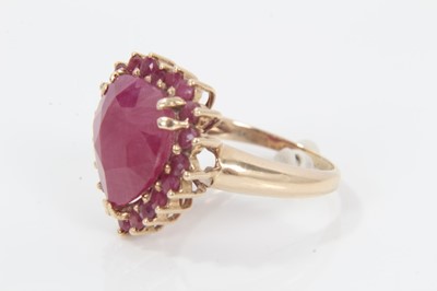 Lot 343 - Ruby and gold heart shaped cluster ring with a large heart-shaped ruby (ruby fracture filled) surrounded by a border of mixed cut rubies on 9ct yellow gold shank. Ring size M.