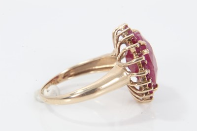 Lot 343 - Ruby and gold heart shaped cluster ring with a large heart-shaped ruby (ruby fracture filled) surrounded by a border of mixed cut rubies on 9ct yellow gold shank. Ring size M.