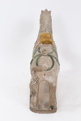 Lot 87 - Chinese Tang-style pottery figure of a horse, partially glazed in yellow and green, standing on a rectangular base, 28cm height