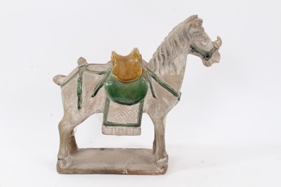 Lot 87 - Chinese Tang-style pottery figure of a horse, partially glazed in yellow and green, standing on a rectangular base, 28cm height