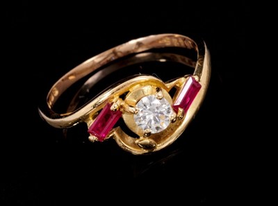 Lot 261 - Diamond and ruby three stone ring with a round brilliant cut diamond weighing approximately 0.25ct flanked by two obliquely set baguette cut rubies in 18ct gold cross-over setting. Ring size M.
