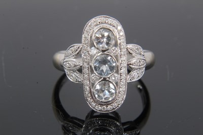 Lot 296 - Art Deco style aquamarine and diamond ring with three round mixed cut aquamarines in an openwork plaque with grain-set brilliant cut diamonds and diamond foliate shoulders on 18ct white gold shank....