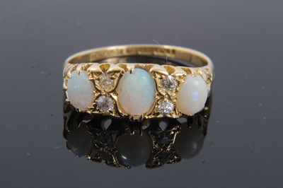 Lot 298 - Edwardian 18ct gold opal and diamond ring with three oval cabochon opals and tour old cut diamonds in gold claw setting with carved gold shoulders on 18ct gold shank, Birmingham 1910). Ring size P½