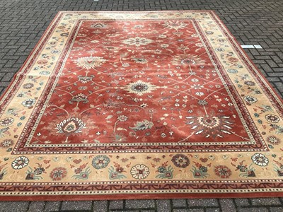 Lot 226 - Large rug with floral decoration on red and beige ground