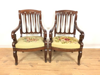 Lot 966 - Pair of 19th century French Empire mahogany elbow chairs with trefoil cut-out decoration, scroll arms and floral taperstry seats on sabre legs