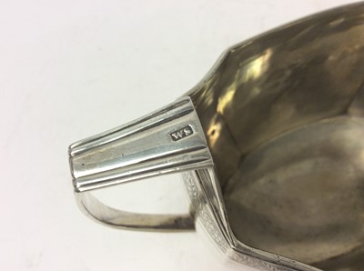 Lot 215 - Georgian Scottish Provincial silver twin handled sugar bowl of faceted octagonal form, with bands of bright cut decoration, reeded borders and an engraved armorial crest. Maker's mark only WS, poss...