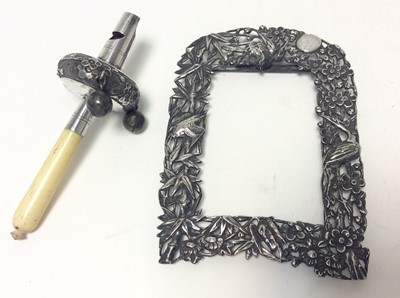 Lot 216 - 19th century Chinese silver photograph frame with pierced decoration of birds, prunus and foliage, together with a Chinese silver babies rattle with turned ivory handle, frame approximately 11.2cm...