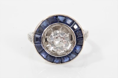 Lot 281 - Art Deco diamond and sapphire cluster ring with a target shaped cluster centred with an old cut diamond estimated to weigh approximately 0.75cts in claw setting with an openwork border and surround...