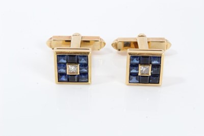 Lot 279 - Pair of diamond and blue sapphire cufflinks, each with a central princess cut diamond surrounded by a border of square calibre cut blue sapphires (possibly synthetic) in gold setting, in an associa...