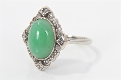 Lot 284 - Art Deco jade and diamond ring with an oval green jade cabochon measuring approximately 11.5mm x 8.2mm x 3.8mm, surrounded by a lozenge shaped border of single cut diamonds in platinum setting with...