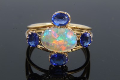 Lot 290 - Opal and blue stone ring with an oval cabochon opal measuring approximately 10.5mmx 7.5mm and four oval mixed cut blue stones in claw setting on gold shank, ring size P½.