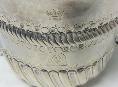Lot 136 - A William and Mary Britannia silver porringer of conventional form, with engraved armorial crest and crown, twin scroll handles, fluted and fish scale decoration and ropework border, (London 1701)