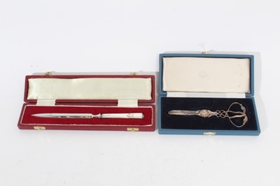 Lot 278 - Elizabeth II silver handled letter opener with steel blade, (Sheffield 1979), in velvet lined fitted case, together with a pair of Elizabeth II silver Grape scissors (Sheffield 1992) also in a fitt...