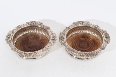 Lot 264 - Pair of 19th century Old Sheffield Plate wine coasters with fluted decoration, shell, scroll and acanthus leaf borders on turned wood bases, 17.5cm in diameter. (2)