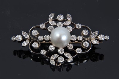 Lot 331 - Edwardian Belle Époque pearl and diamond brooch, the openwork plaque with floral scrolls and set with a central pearl (not tested for natural origin) measuring approximately 7.8-8.1mm surrounded by...