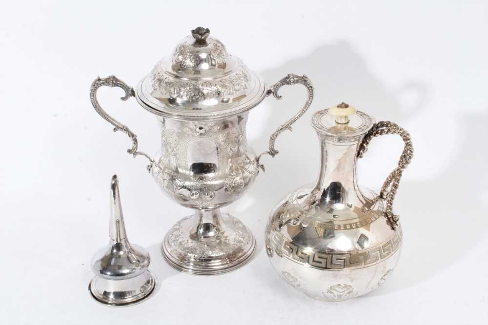 Lot 64 - Victorian silver plated two handled trophy cup and cover of campana form with embossed and chased decoration and twin scroll handles together with a Victorian Greek Revival silver plated jug and an...